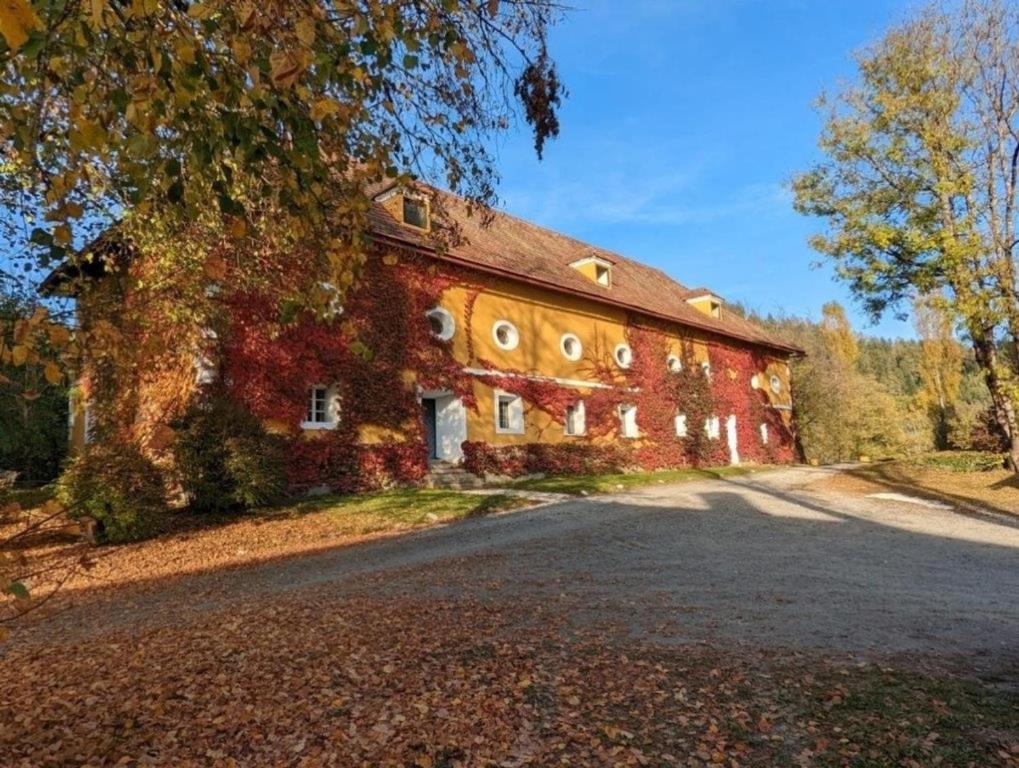 an old red brick barn with a road in front of it at Gut Ottmanach "Josefhof" in Pischeldorf