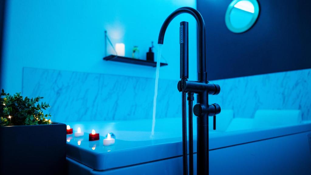 bagno con lavandino e doccia con illuminazione blu di L'Atelier de rêves a Metz