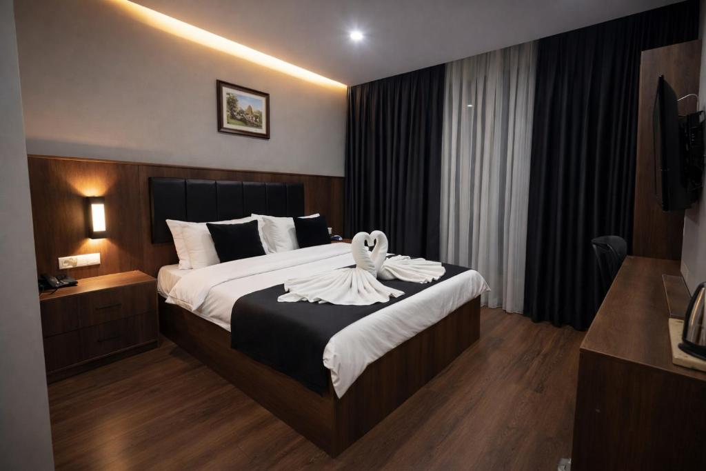 a hotel room with a bed with a towel on it at BZN Airport Hotel in Arnavutköy