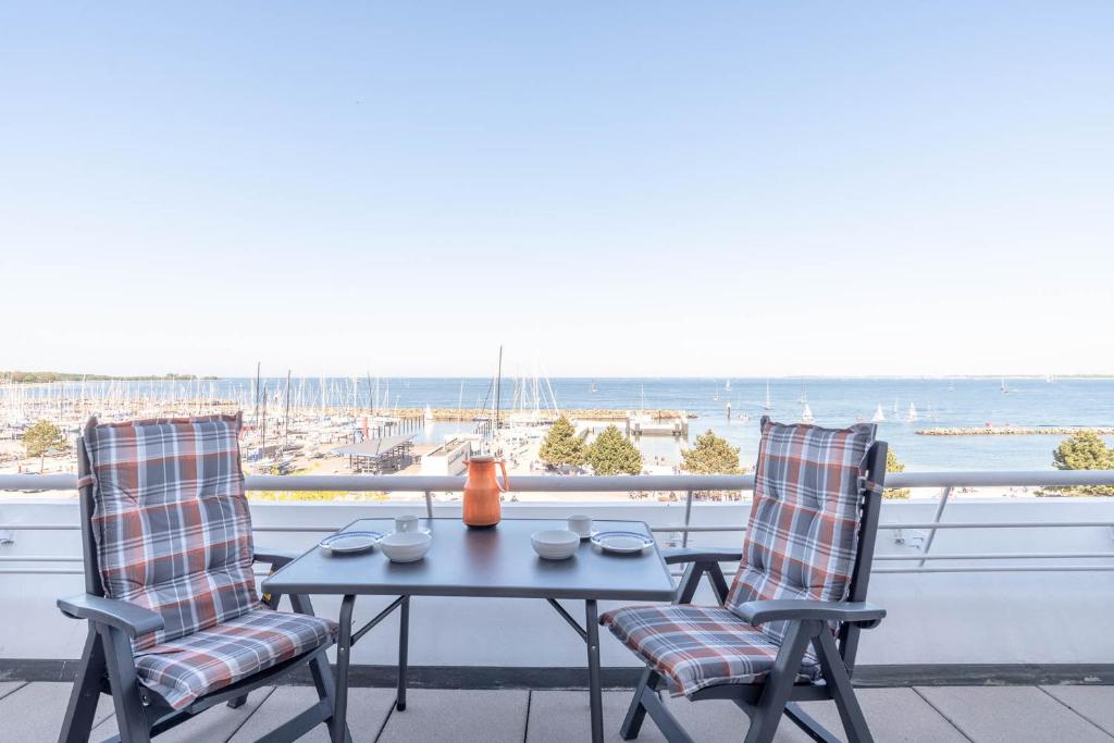 a table and chairs on a balcony with a view of the ocean at Kiel Water 4 in Schilksee