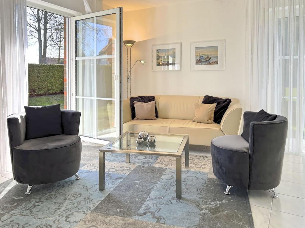 a living room with a couch and two chairs and a table at Windwatt 2 in Zingst
