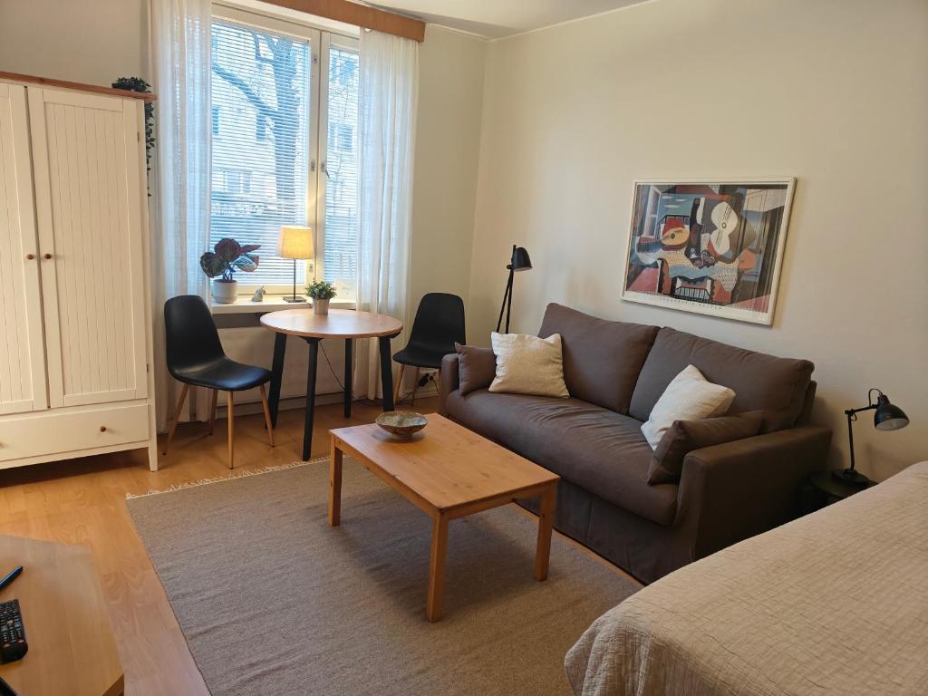 een woonkamer met een bank en een tafel bij Eskolampi in Helsinki