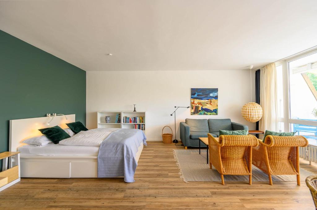 een slaapkamer met een bed, een bank en een stoel bij Strandläufer in Schilksee