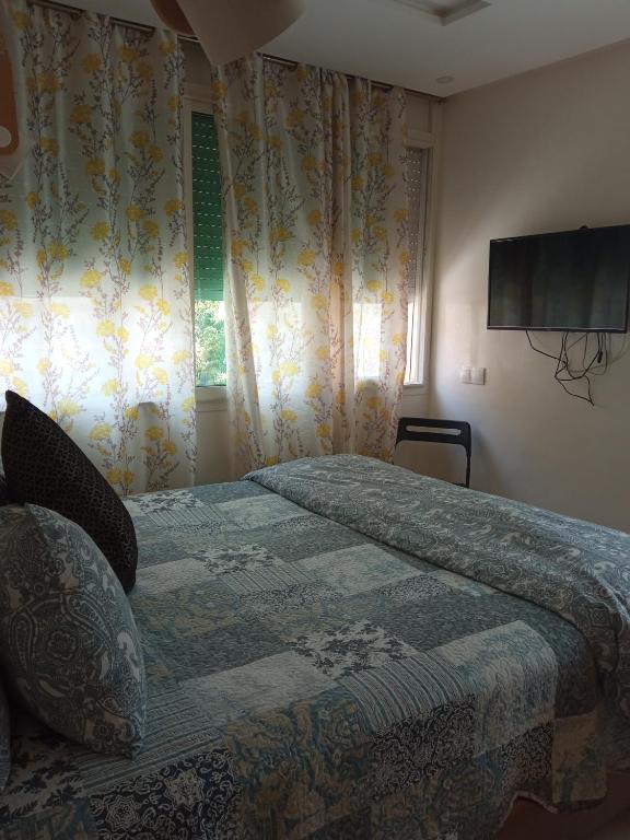 a bedroom with a bed with a television on the wall at home & room center of rabat in Rabat