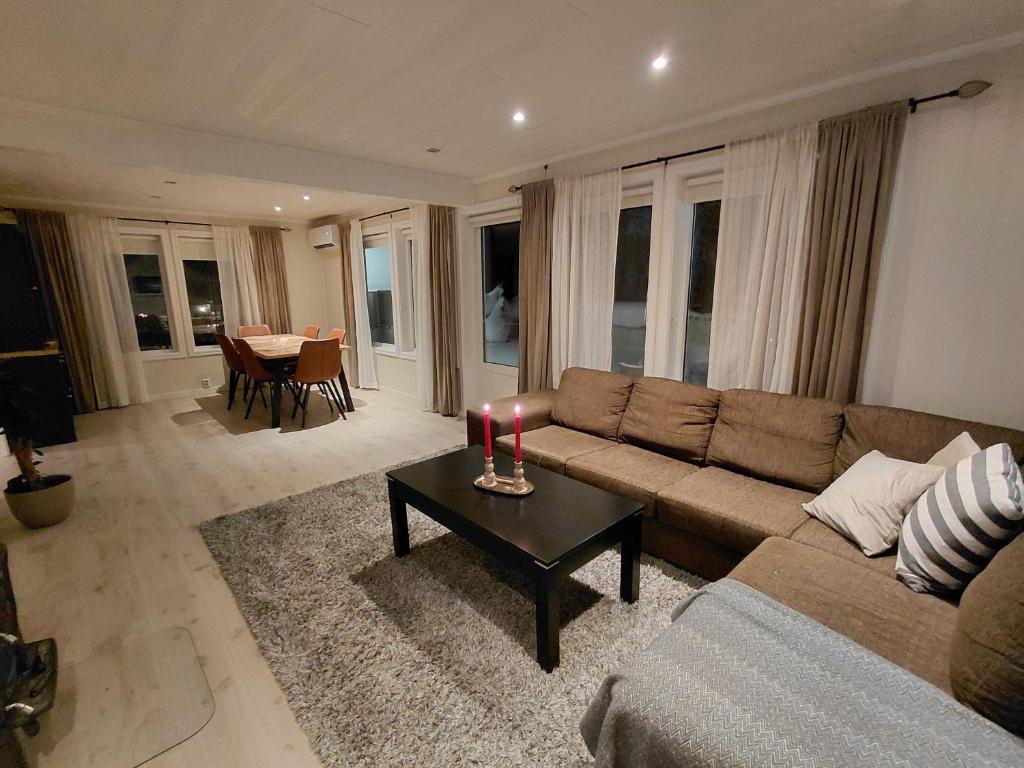 a living room with a couch and a table with a candle at Artic home komfort in Tromsø