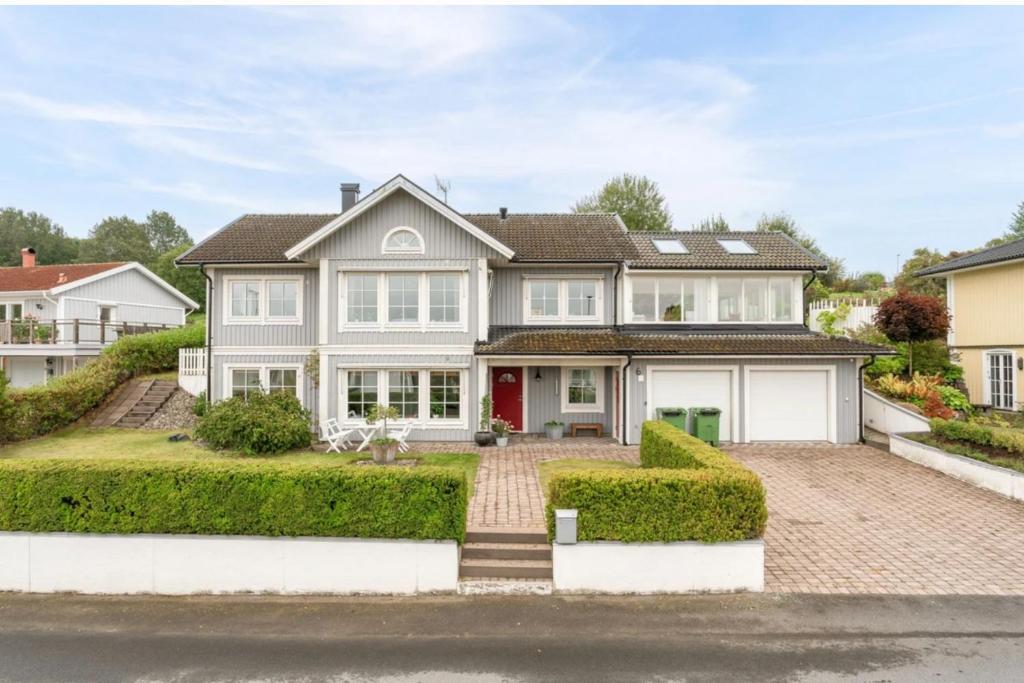 a large white house with a red door at House close to the forest and the lake in Huskvarna