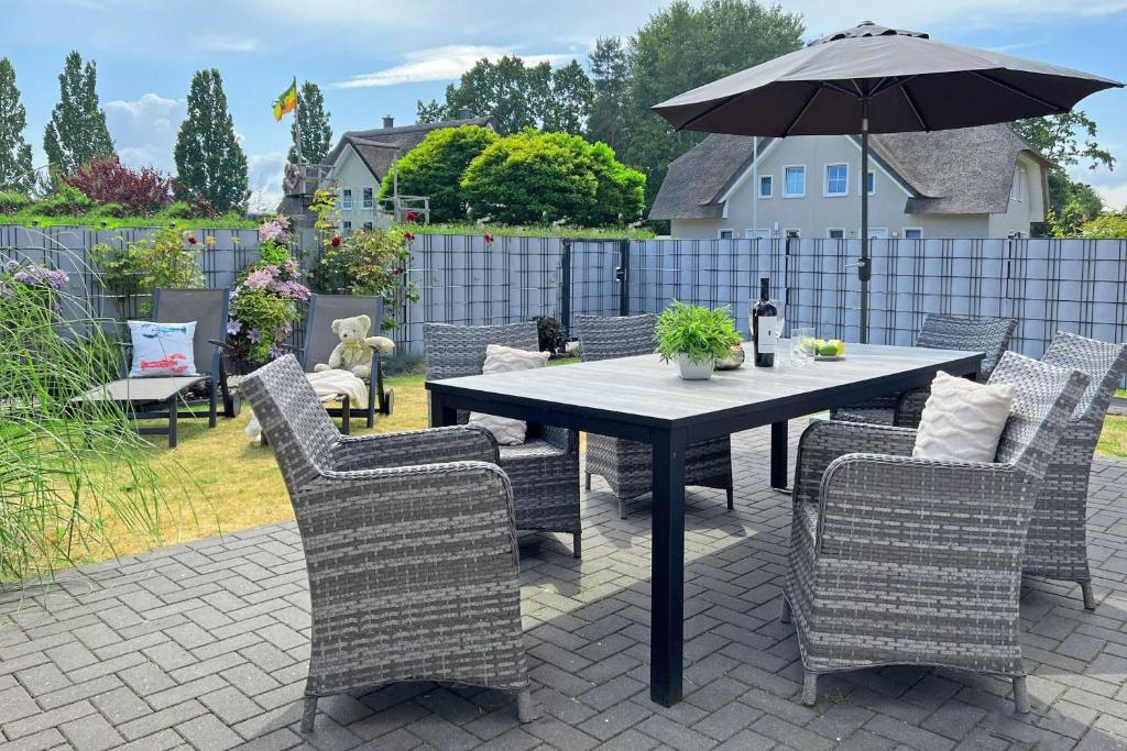 a table and chairs with an umbrella on a patio at Kleiner Seehund in Groß Kirr
