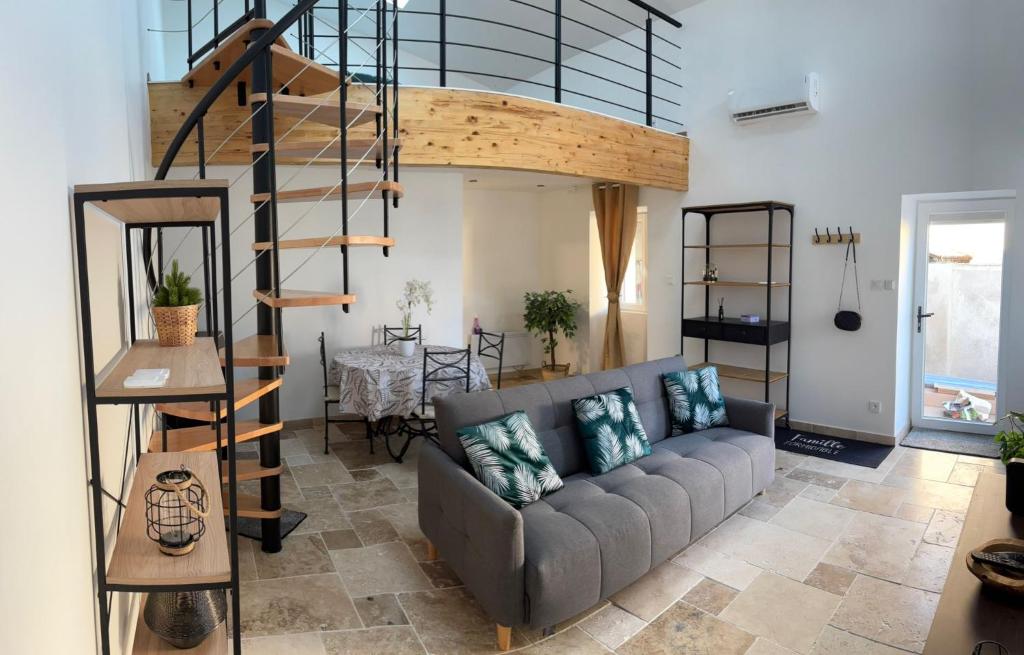een woonkamer met een bank en een wenteltrap bij Le loudunais in Loudun