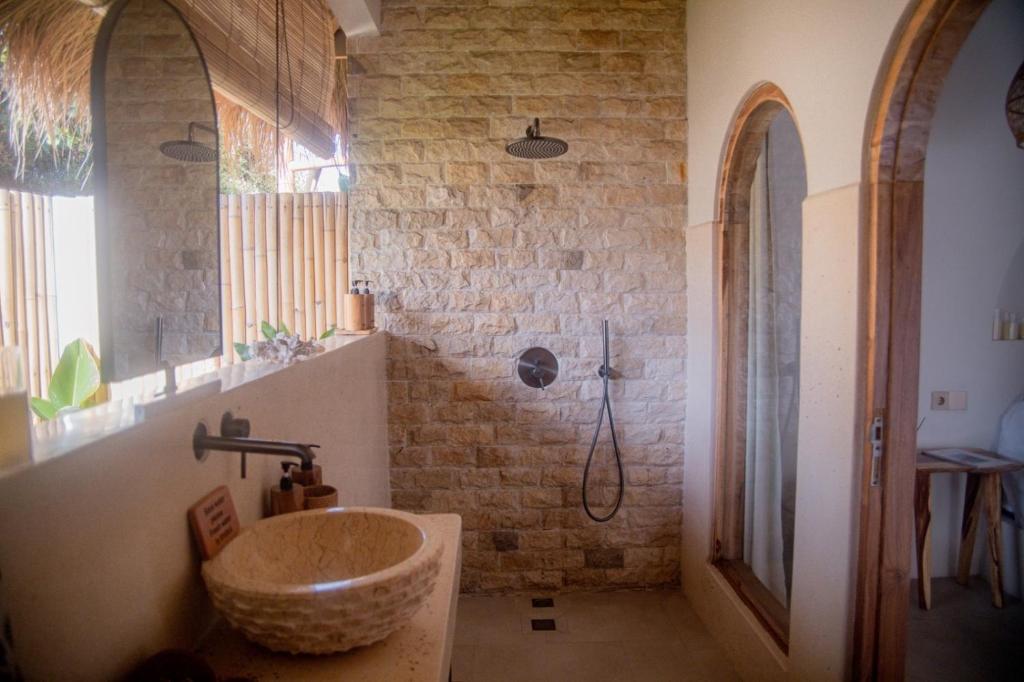 ein Badezimmer mit Waschbecken und Dusche in der Unterkunft Villa Nyantara in Gili Air