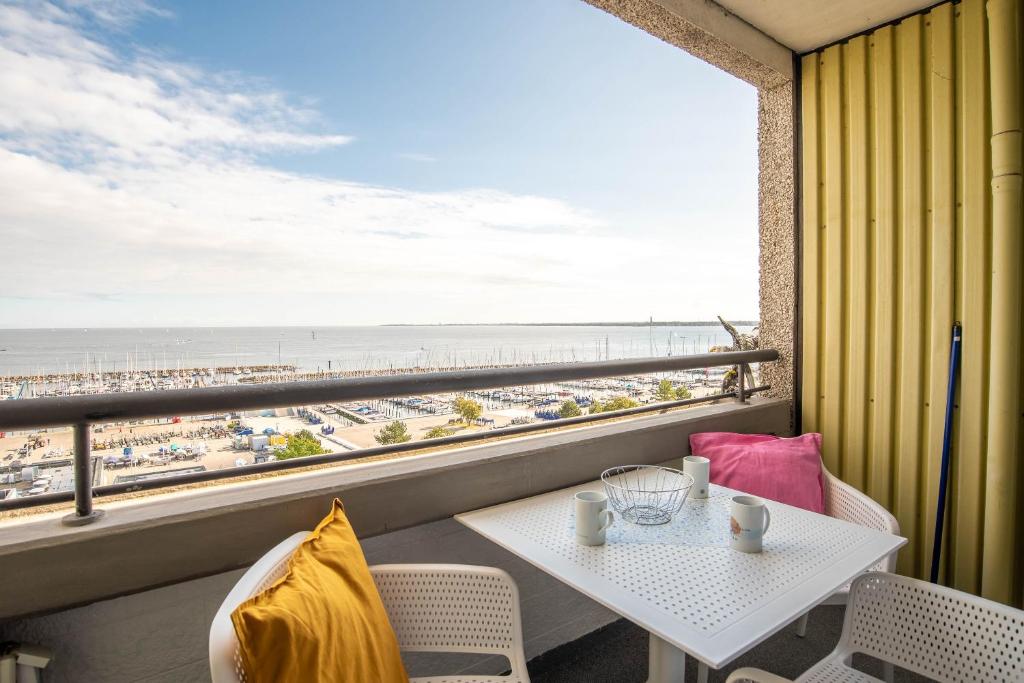 ein Balkon mit Tisch und Blick auf den Strand in der Unterkunft Immerschön in Schilksee