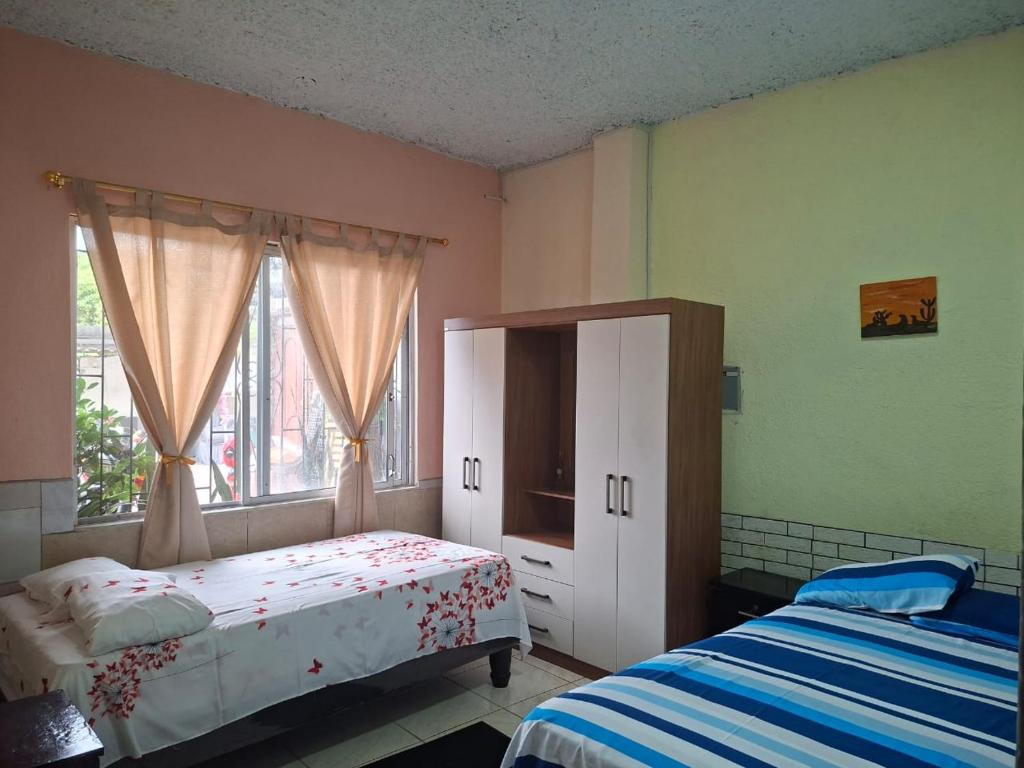 a bedroom with a bed and a cabinet and a window at Casa Albacora in Puerto Baquerizo Moreno