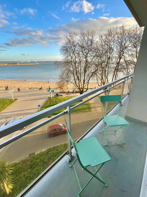 a balcony with a chair and a view of the beach at Apartment with exceptional views in Saint-Nazaire