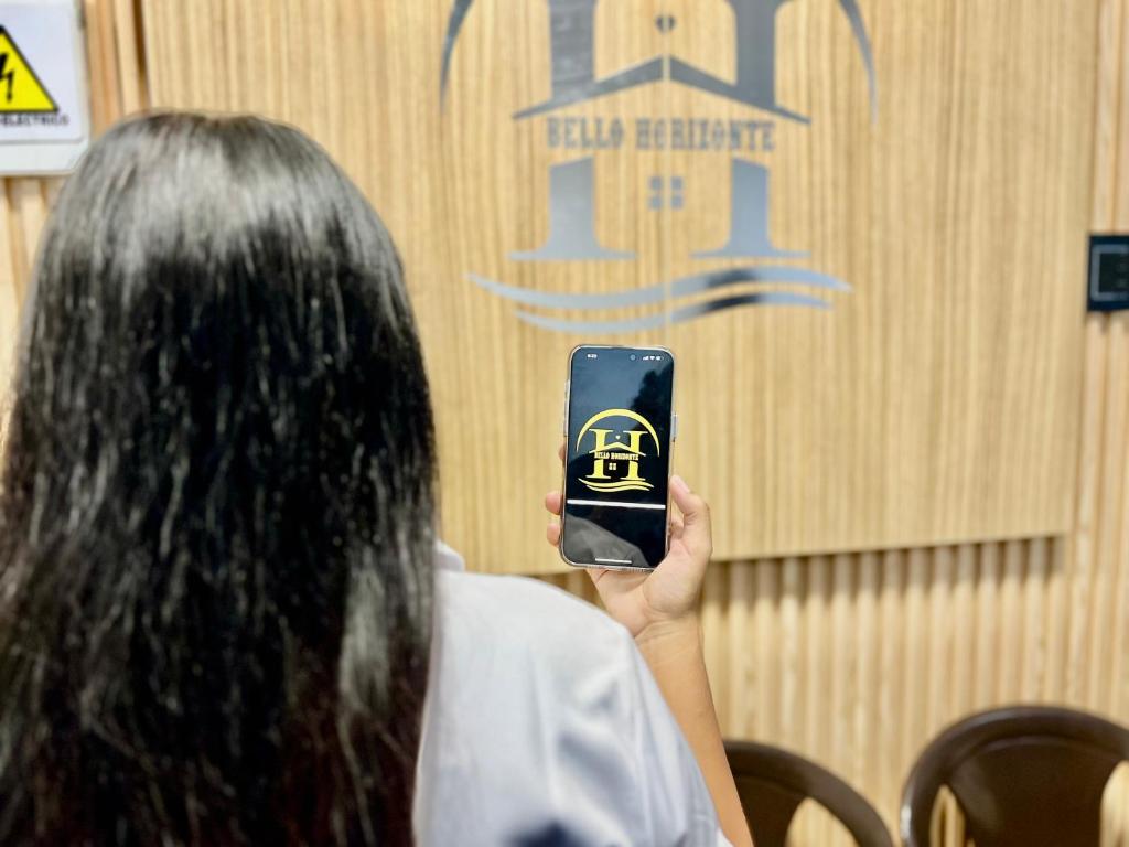 a woman taking a picture with her cell phone at Hotel Bello Horizonte in Santa Marta