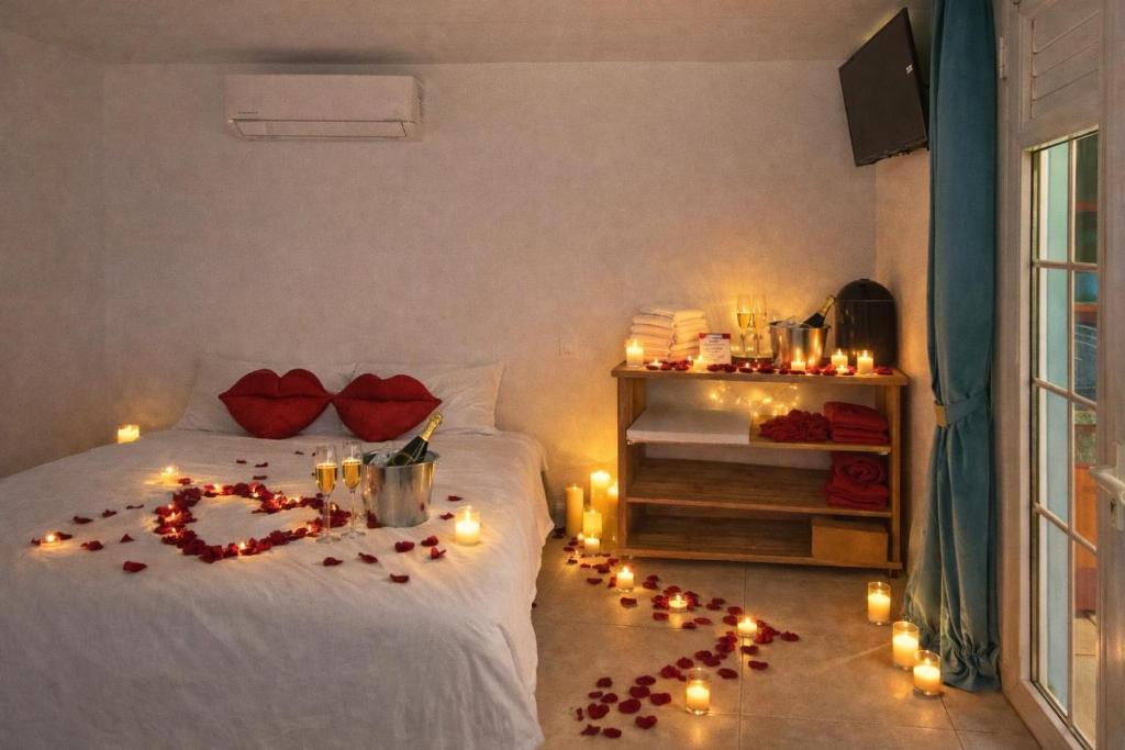 a room with a bed with candles and lights on it at L'ilot secret in Le Robert