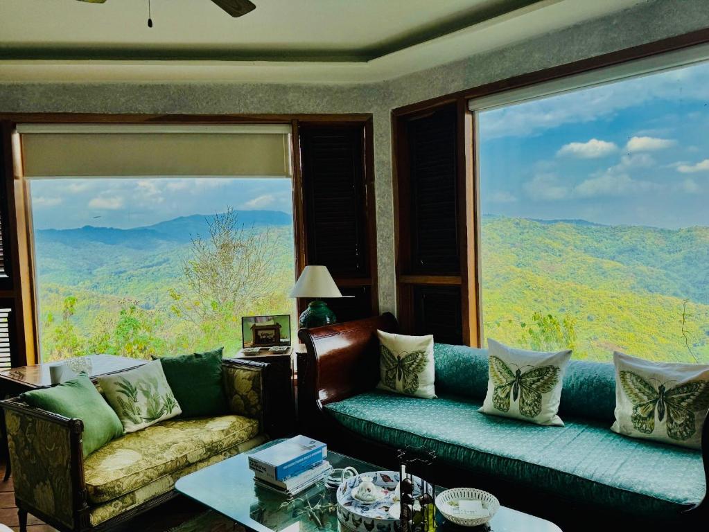 a living room with a couch and a large window at The Chaisai Private Lodge in Ban Huai San Mai