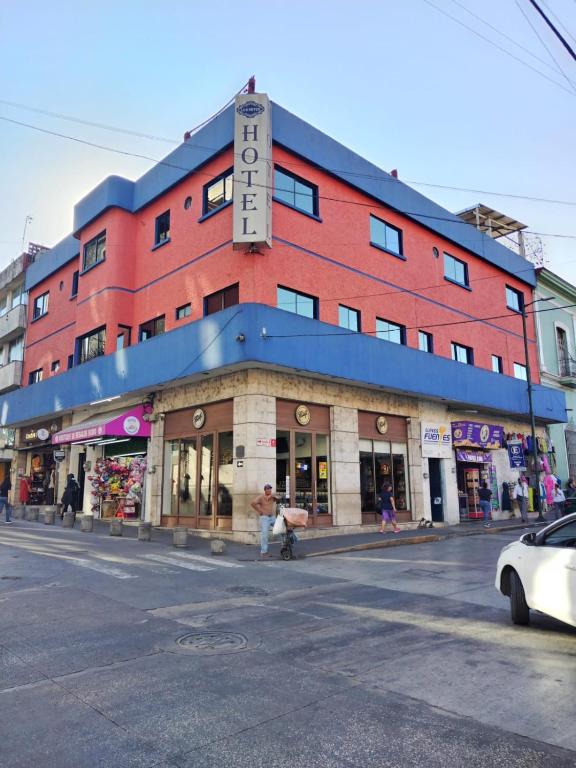 a red building with a sign on top of it at Hotel Los Reyes in Córdoba