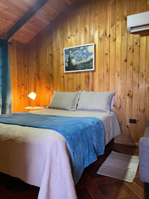 een slaapkamer met een bed in een houten wand bij Cabañas Valentina in Valdivia