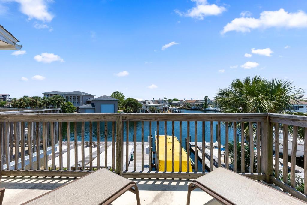 a deck with two chairs and a yellow surfboard at Allendale Docks in Destin