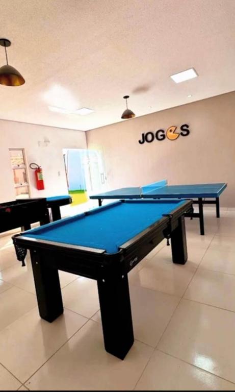 a ping pong table in a room with a pool at NG Flat seu refúgio do mar in João Pessoa