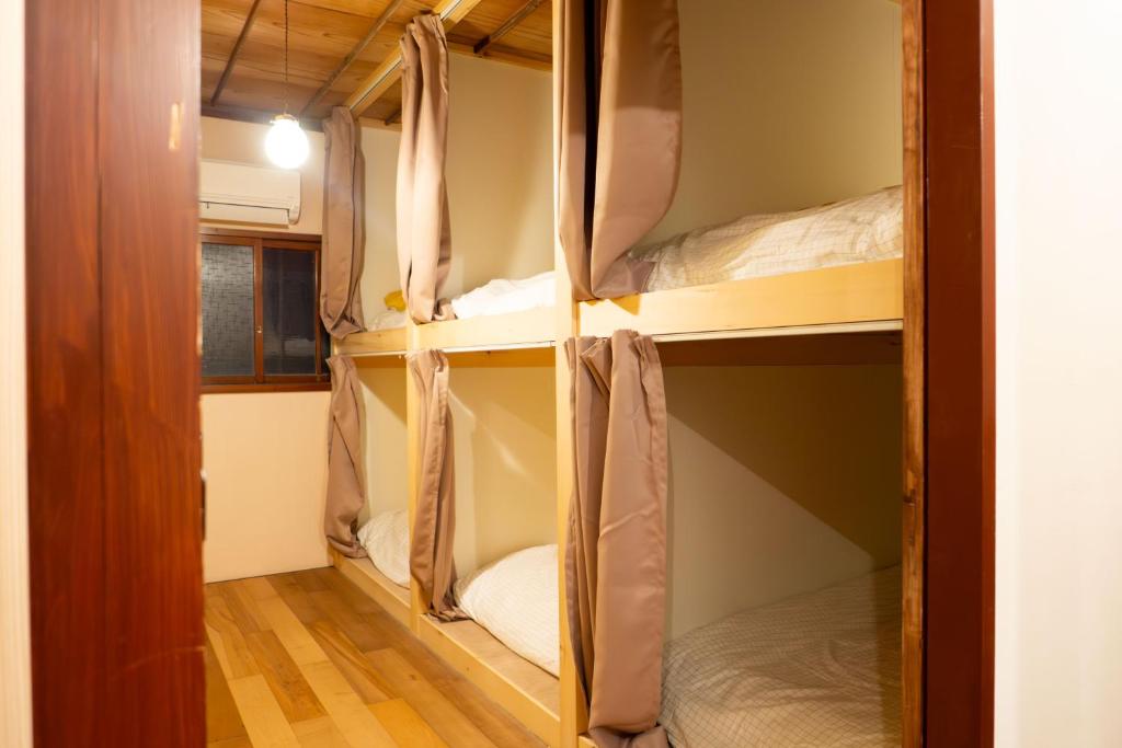 a room with three bunk beds in it at Guest House KITOEDA in Nikko