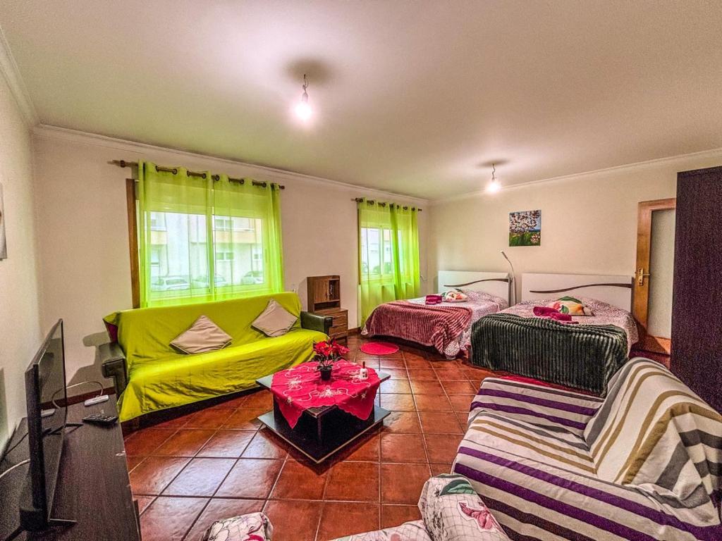 a living room with two beds and a yellow couch at Family holiday home new beds in Bragança