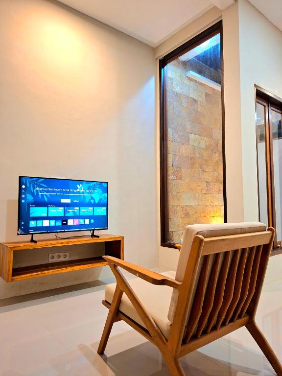 a living room with a chair and a television at Omi Homestay in Praya