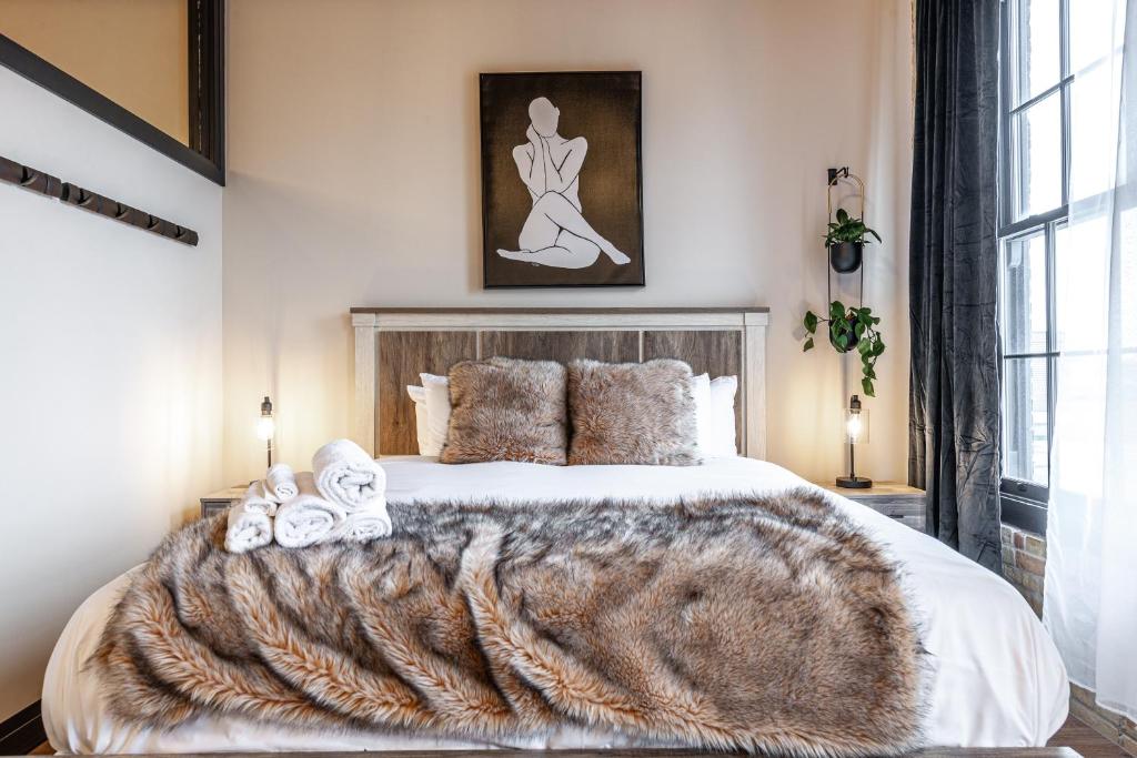 a bedroom with a large bed with a fur blanket at Bradshaw Lofts The Brixton King Suite in Stratford