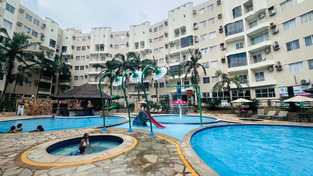 a large swimming pool in front of a large building at Thermas Paradise Apartamentos Rio Quente Esplanada in Rio Quente