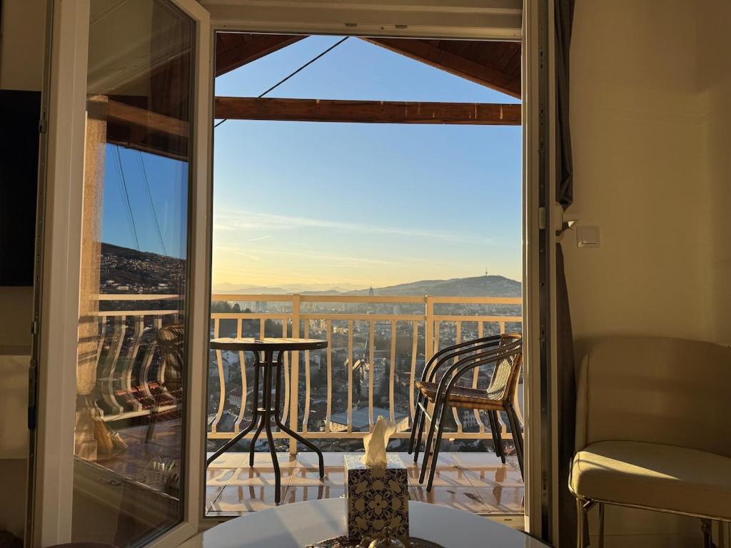 a room with a view of a balcony with a table and chairs at SarajevoView in Ivišovo Greblje
