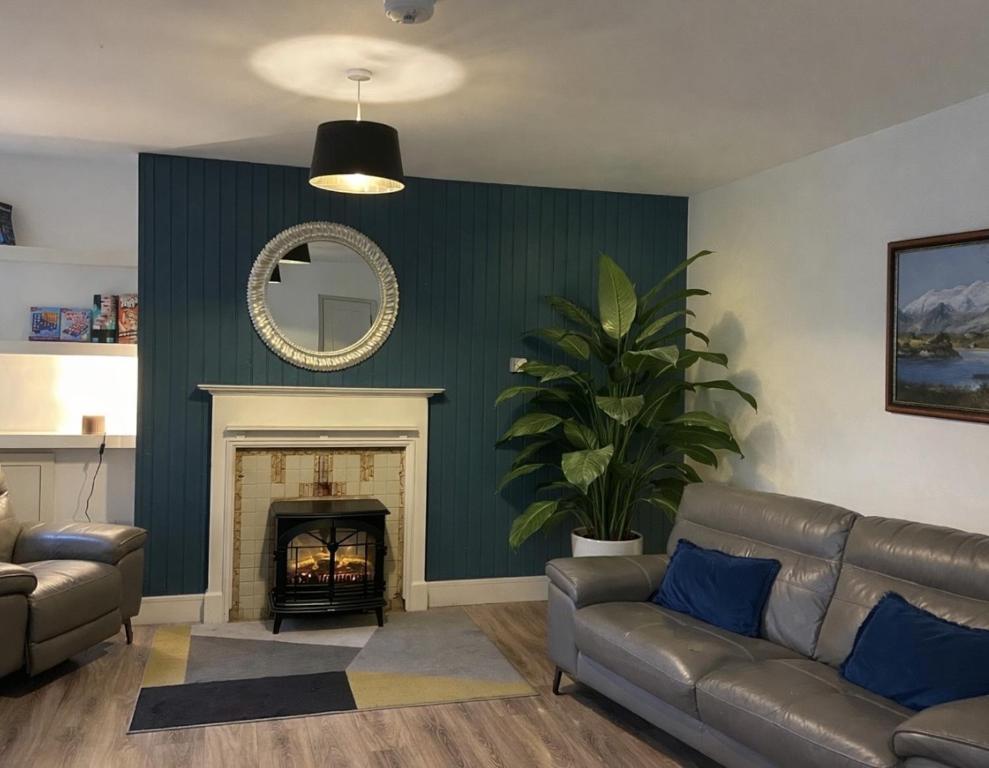 a living room with a couch and a fireplace at Shangri-La Large Family Townhouse free carpark in Killarney