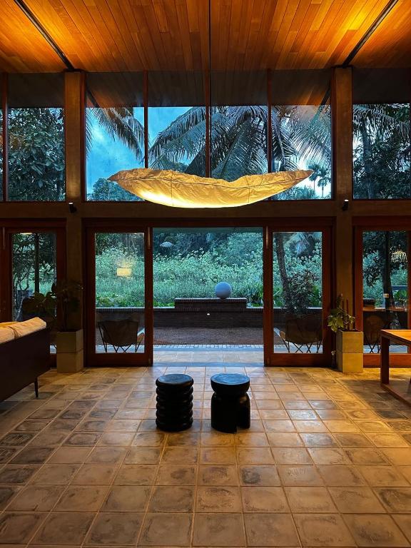 a large living room with a large ceiling with windows at Clover Bentota in Dedduwa