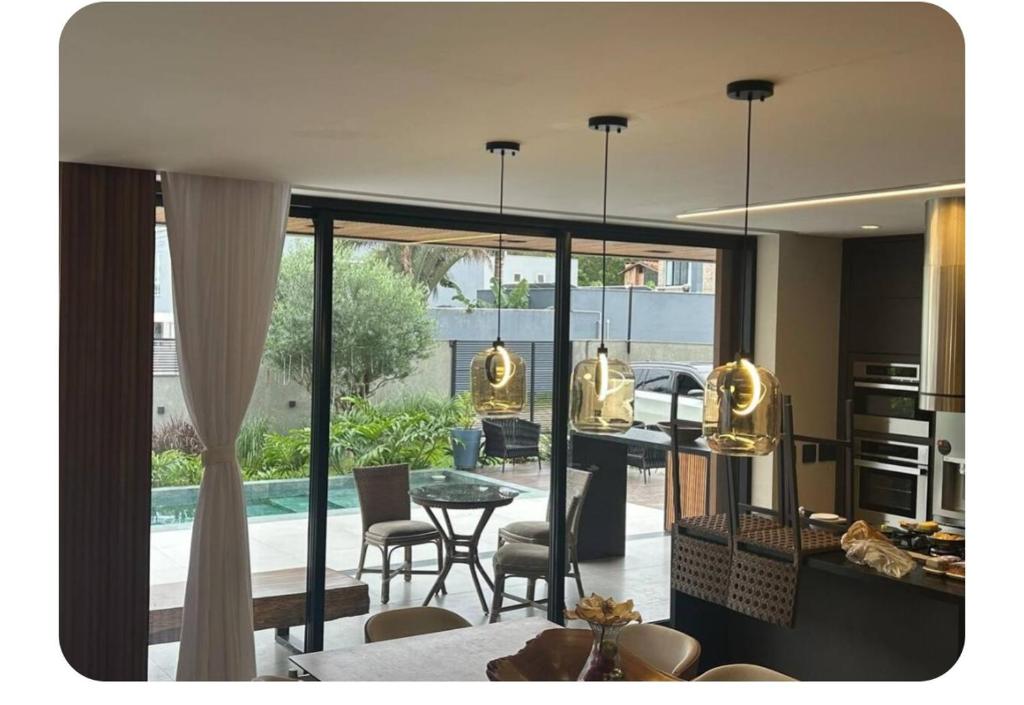 a kitchen and living room with a table and chairs at Casa de luxo com piscina in Florianópolis