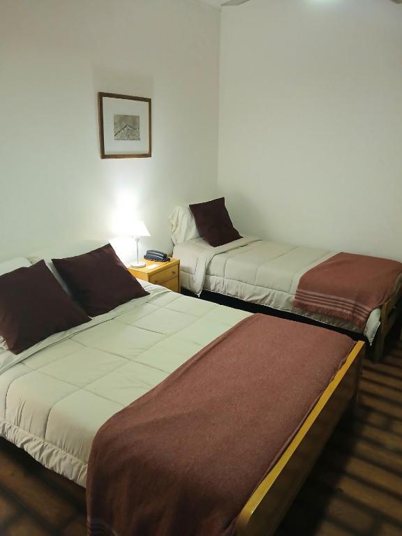 two beds in a hotel room with at Hotel Ancon in Buenos Aires
