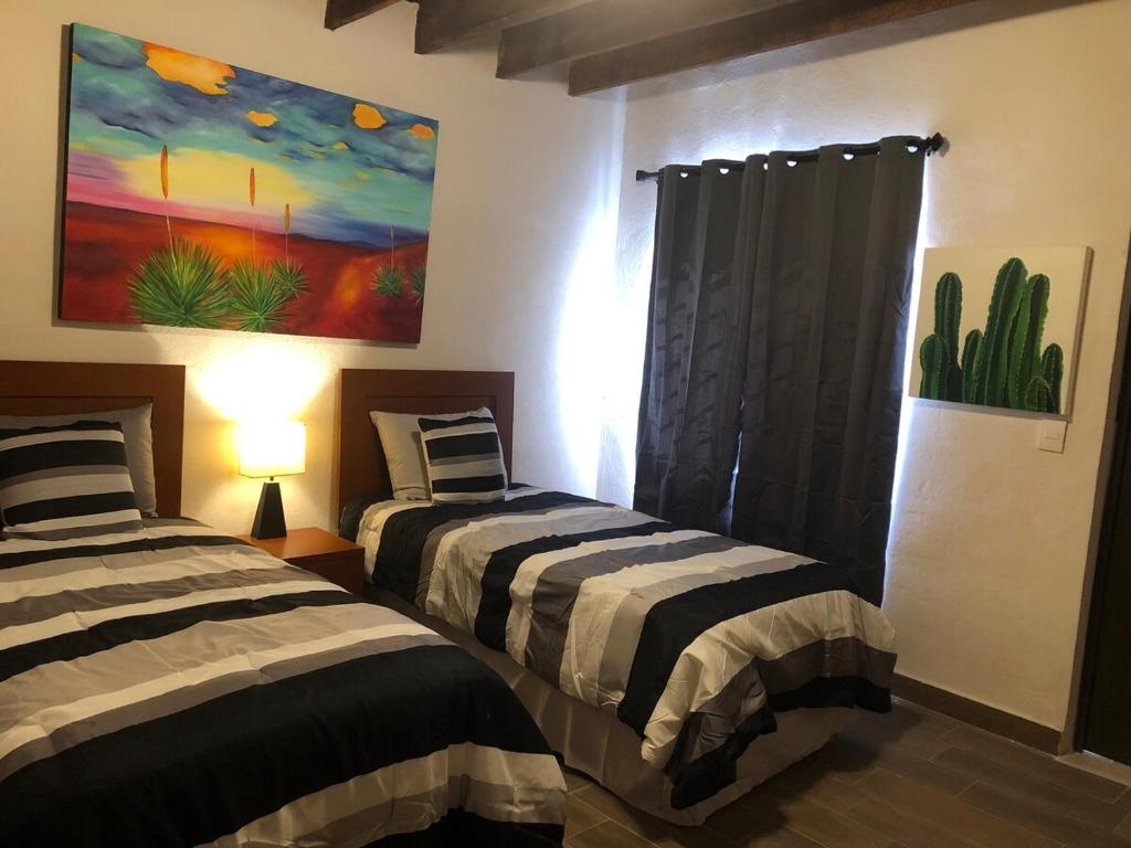 2 letti in una camera con un dipinto sul muro di Casa del Olivo bedroom 3 a Parras de la Fuente