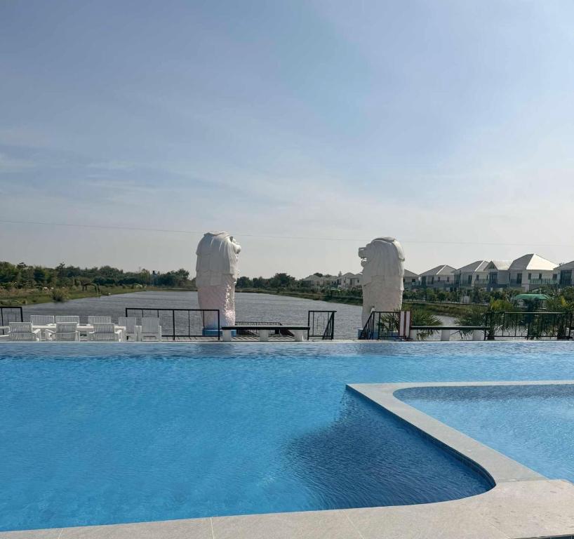 a large swimming pool with tables and chairs next to the water at Alayah บ้านเดี่ยวสองชั้น ธาดาดิโอเอซิส in Ban Krok Khi Nu
