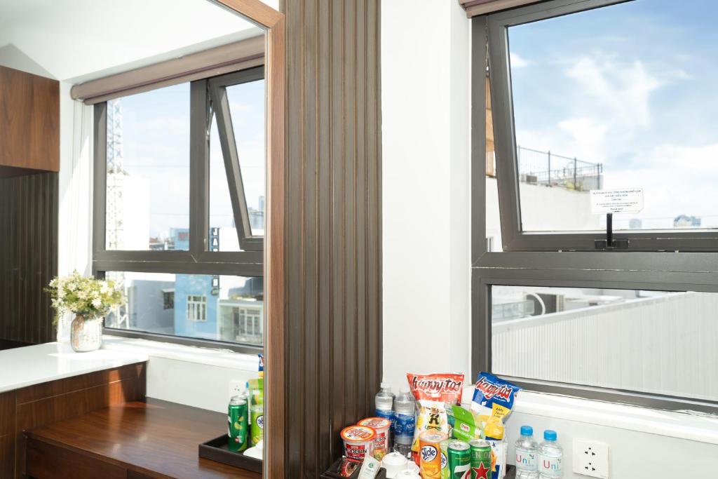 A window-lined kitchenette with a counter, drinks and views of surrounding buildings.