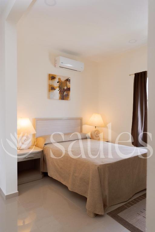 a bedroom with a bed with two lamps on it at Saules Sueño in Cancún
