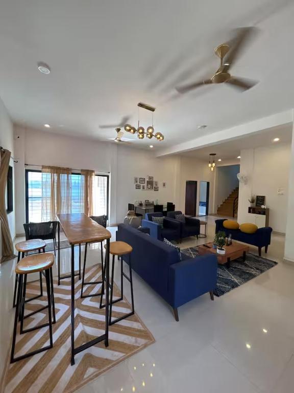 a living room with a blue couch and a table at Sandbox in Malvan