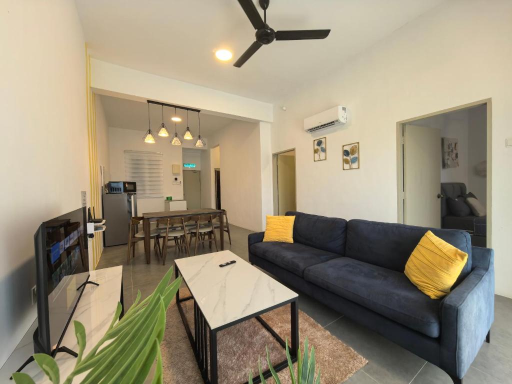 a living room with a blue couch and a table at Langkawi Simfoni Lavanya Suite 13 in Kuah