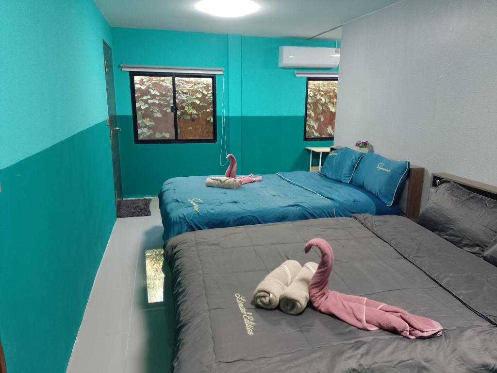 una camera da letto con due letti con sopra dei fenicotteri rosa di BP family room 4 a Ko Mak