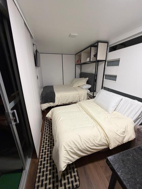 two beds in a small room with a table at Sendero Nativo Glamping in Monguí