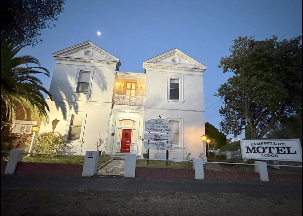 un edificio bianco con un cartello davanti di Campbell st Lodge a Castlemaine