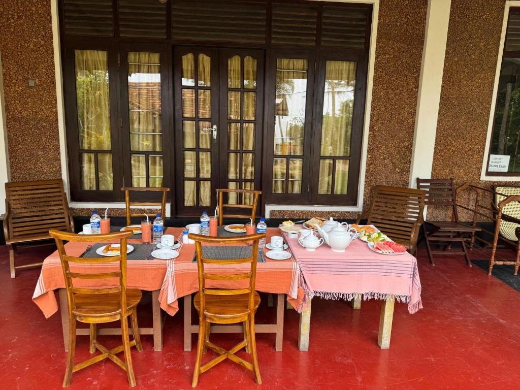 tavolo con sedie e tavolo con cibo sopra di Westrom Villa Ocean Front a Bentota