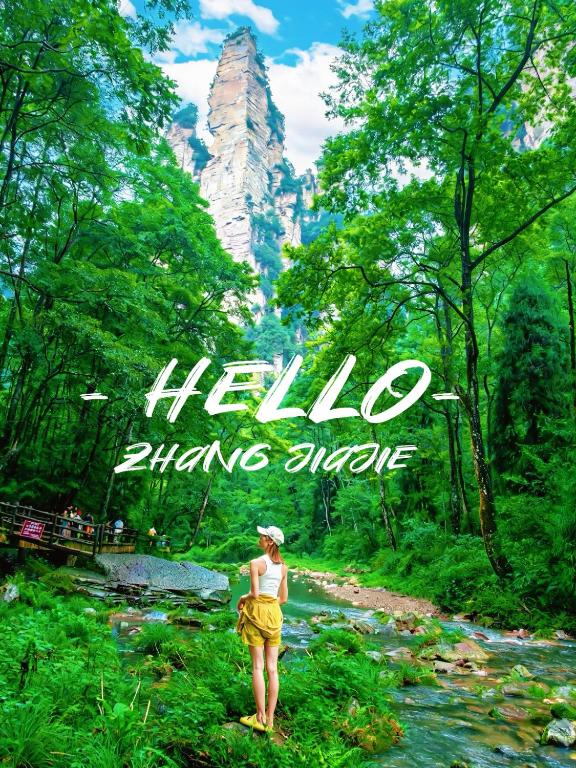 a woman standing in front of a mountain with the text hello china singapore at Zhangjiajie Zhenxi Hotel- Near Forest Park EastGate about 10 Min Walk - English Butler, Free Luggage Storage, Tour Plan -reserve tickets for various scenic spots-Self-Service Laundry,Free coffee, Chinese tea in Zhangjiajie