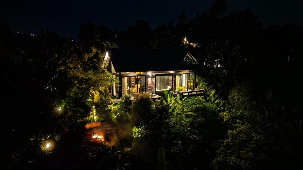 a house lit up at night with lights at Wanagiri Cabin Wanara in Gitgit
