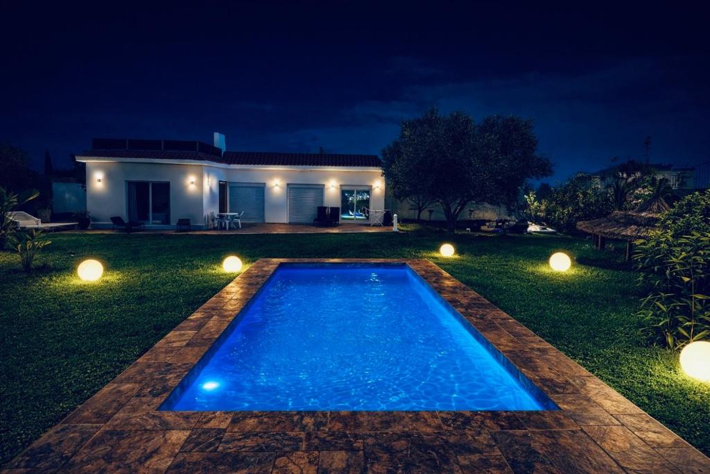 een zwembad voor een huis 's nachts bij Luxury Villa with Pool & Garden5km from Cabo in Tetouan