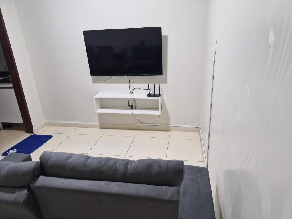 a living room with a couch and a flat screen tv at Próximo a roda gigante in Maceió