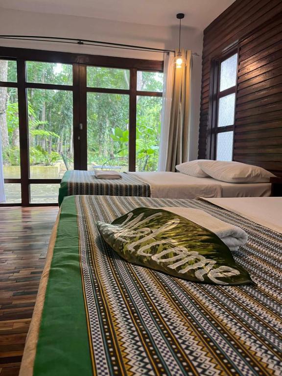 a bedroom with two beds and a large window at Baluarte Rest and Relaxation in Sampong
