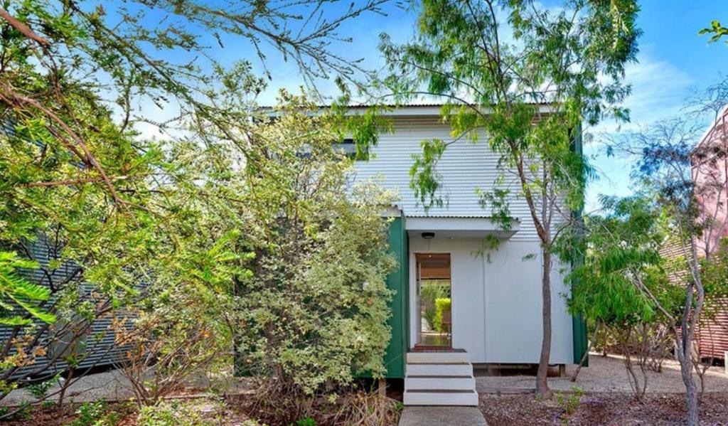 a white house with a green door and trees at La Casita Preston Beach in Preston Beach