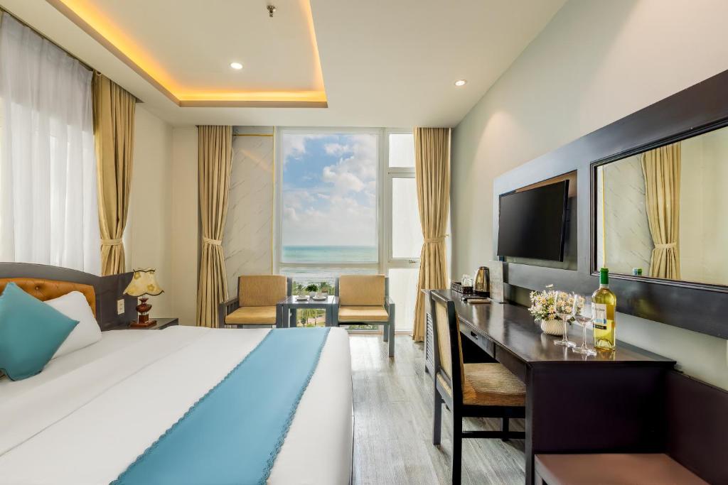 a hotel room with a bed and a desk and a television at Chill Hotel Ha Bong in Danang
